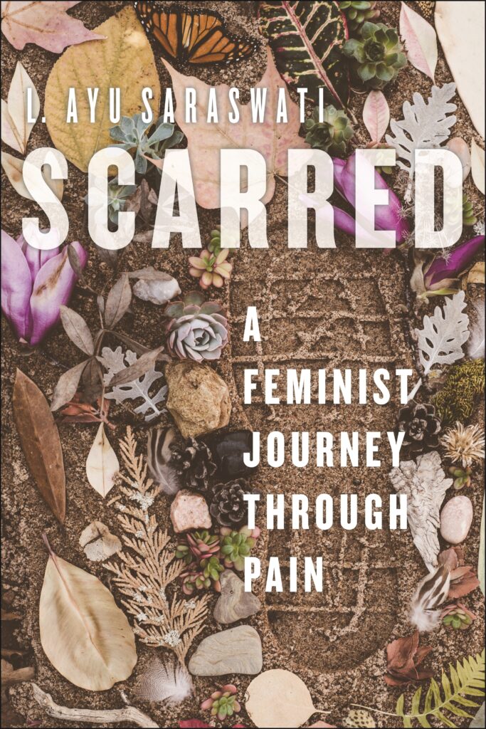 Book cover for Scarred: A Feminist Journey Through Pain by L. Ayu Saraswati. The book cover shows a photograph of a footprint in soil, surrounded by an array of leaves, stones, and flowers.