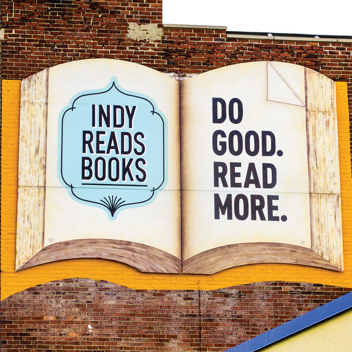 There is an open book painted on a large brick wall. On the lefthand page is the logo for IndyReads Books. On the righthand page, text reads: "Do Good. Read More."